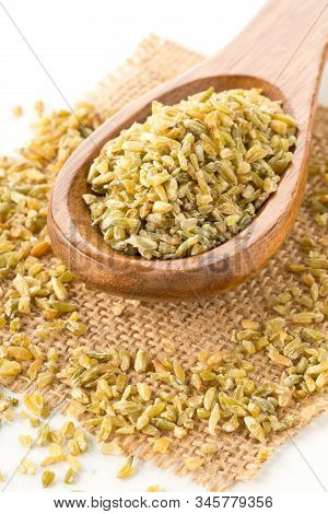 Heap Of Uncooked, Raw Freekeh Or Firik, Roasted Wheat Grain, In Wooden Spoon On Freekeh Grain And Bu
