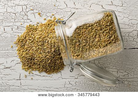 Heap Of Uncooked, Raw Freekeh Or Firik, Roasted Wheat Grain, In Glass Storage Jar On White Rustic Ta