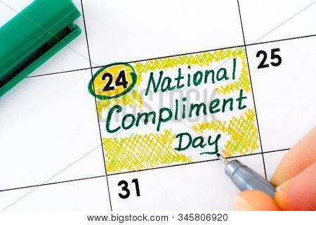 Woman Fingers With Pen Writing Reminder National Compliment Day In Calendar. January 24.