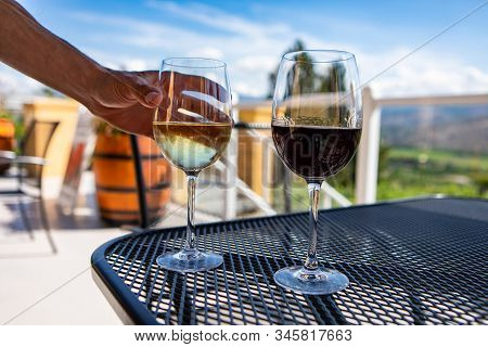 White And Red Wine Glasses On The Table, Hand Choosing And Holding White Glass, Selective Focus And 