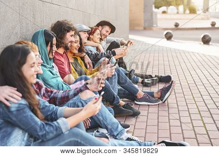 Group trendy friends using smart mobile phones outdoor - Millennial people having fun with new technology trends smartphone ,Youth generation lifestyle and tech addiction social media concept