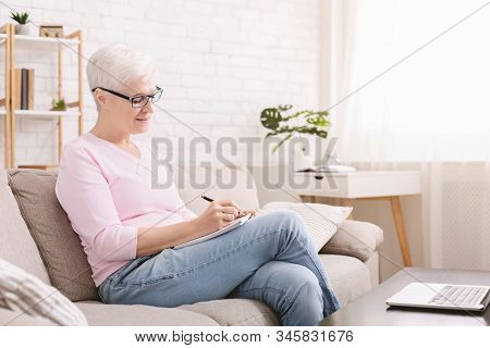 Self Development. Retired Lady Writing Notes Using Laptop At Home, Empty Space