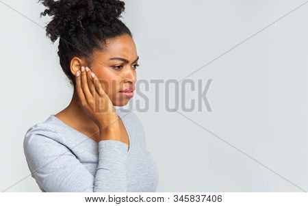 African Girl Suffering From Otitis, Rubbing Her Inflamated Ear Over Grey Background, Ear Diseases Co