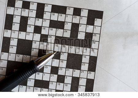 Crossword Puzzle From Newspaper With A Pen To Fill In Answers