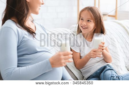 Close Up Of Preschooler Happy Girl Enjoying Milk With Her Pregnant Mom, Nutririon And Healthy Lifest