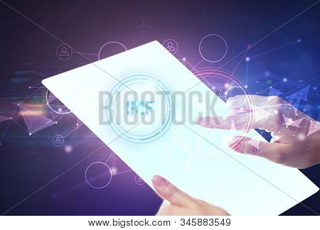 Hand holdig futuristic tablet with IMF inscription, modern technology concept