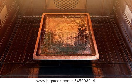 A Close View Inside A Hot Operational Household Oven With An Empty Tarnished Baking Tray - 3d Render