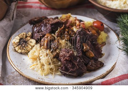 Beef Cheeks With Potato, Sauerkraut And Mushrooms On A Plate.