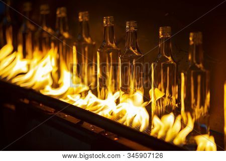 Glassworks. Glass Industry. Making Glass Bottles. Hot Bottle Blanks In Flame