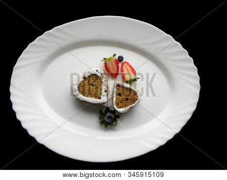 Two Heart-shaped Pies On A White Plate On A Black Background
