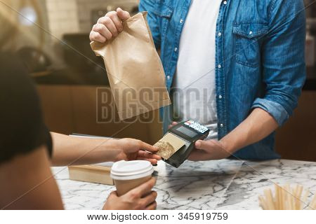 Barista Man Standing Behind The Bar Sells Hot Coffee Drink And Lunch In Paper Bag To Woman Client Fo