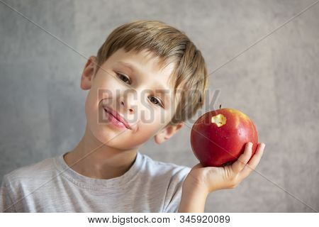 Child With Fruit. Funny Boy With Bitten Beautiful Apples