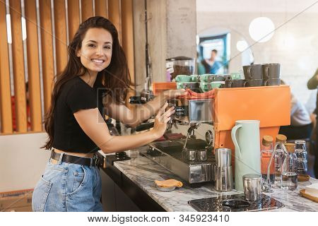 Young Smiling Barista Woman Cleaning Professional Coffee Machine With Dust , Barist Work Routine