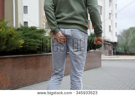 Man Suffering From Hemorrhoid Pain Outdoors, Closeup