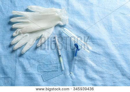 Anoscope, Rubber Gloves And Syringe On Light Blue Fabric, Flat Lay. Hemorrhoid Treatment