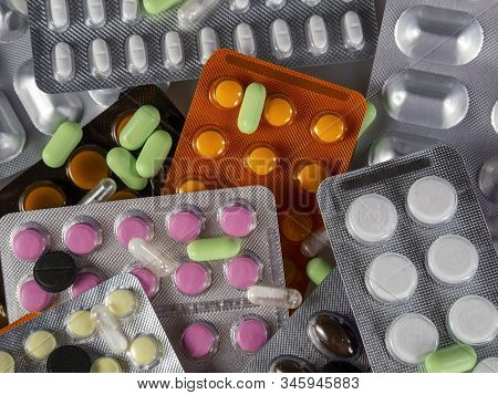 Medicines In Blisters Of A Round And Oblong Shape In Different Colors. On Them Are Separate White Ca