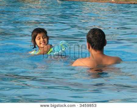 Little Girl nuoto nella piscina con suo padre