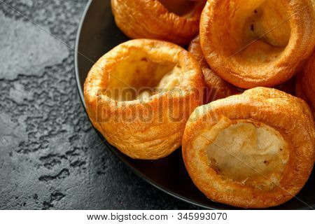 Traditional English Yorkshire Pudding Side Dish On Black Plate And Background
