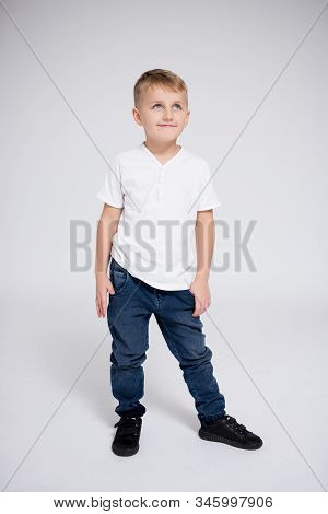 Full Length Portrait Of Cute Little Boy Thinking About Something Over White Background