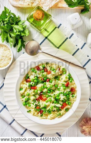Risi E Bisi, Venetian Risotto With Spring Peas And Chunks Of Ham In A Bowl On A White Table With Ing