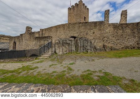 Outdoor Ruins Of Medieval Bourscheid Castle, Weathered Stone Walls, Staircase, Metal Railing And Tow