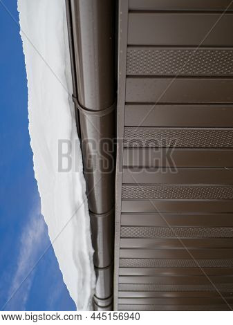 Snow Hanging On The Roof Drainpipe. The Drainpipe Are Covered With Snow.