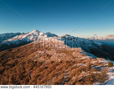 Aerial View Of A Ridge At The Col De Battaglia Leading Towards The Snow Covered Peak Of Monte San Pa