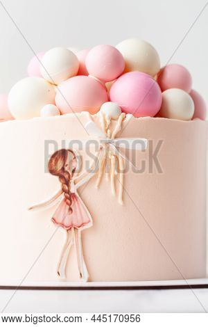 Birhtday Cake For A Girl With Chocolate Spheres Decoration On Top. Little Girl Holding Air Balloons.