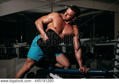 Sport Man Man Doing Biceps Lifting In A Gym. Portrait Of Young Athlete Doing Exercise With Dumbbell 