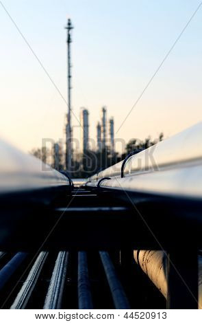 Long Pipe And Silhouette Of Oil Refinery