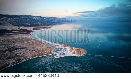 Frozen Lake Baikal From The Air. Transparent Ice, In Which Clouds Are Reflected. Winter Trip. Cape T