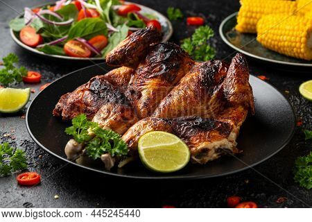 Roast Chicken Tabaka With Salad, Corn And Lime On Black Plate.