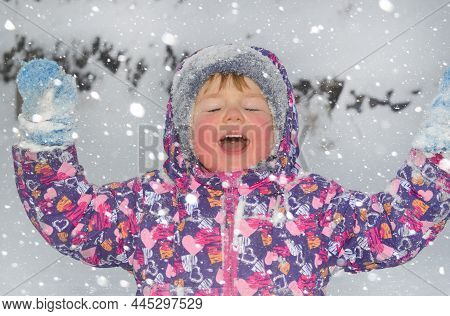Caucasian Child In Winter Clothing Playing Outdoors