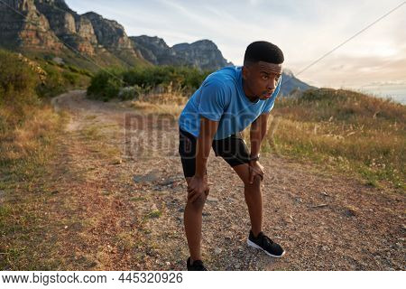 Black Young Adult Male Catching His Breath After A Sprint On His Outdoor Run. Athletic Physique