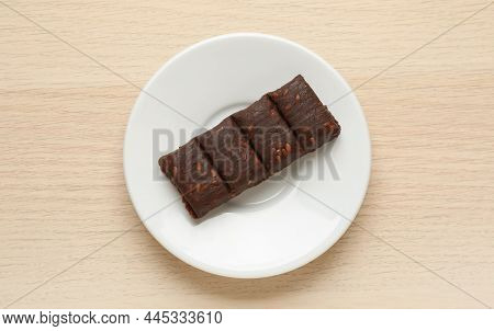 White Plate With Delicious And Healthy Hematogen Bar  On Wooden Table, Top View