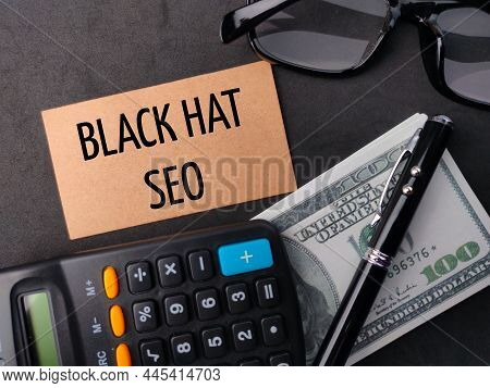 Calculator,pen,banknotes And Glasses  With Text Black Hat Seo On Black Background.