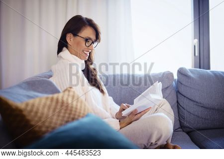 Attractive Woman Reading A Book While Relaxing At Home