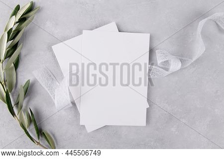 Two Blank Wedding Invitation Stationery Card Mockup On Grey Stone Table Background With Olive Branch