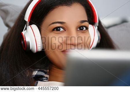 Portrait Of Latino American Young Woman Wear Headset And Watch Movie Or Take Online Class. Smiling F