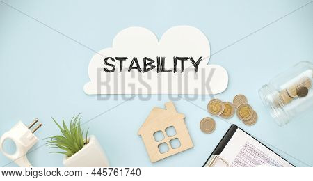 Stability Text On White Paper On Blue Background And Coins.
