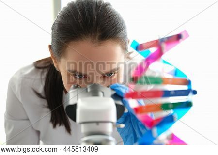 A Woman Biologist Looks Through A Microscope Close-up. Dna Sample. Genetics Research. Pharmaceutical