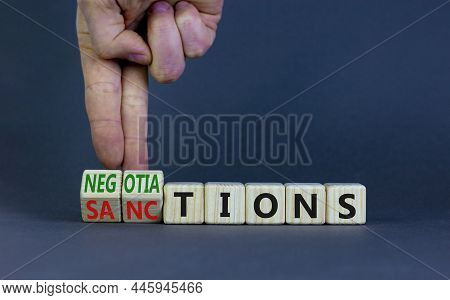 Sanctions Or Negotiations Symbol. Businessman Turns Cubes, Changes The Word Sanctions To Negotiation