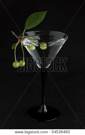 Unripe Green Cherry In Martini Glass On Black
