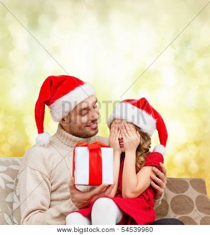 family, christmas, x-mas, winter, happiness and people concept - smiling daughter with closed eyes waiting for a present from fathe