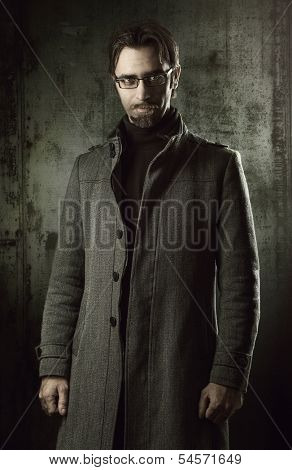 handsome man in black coat over metallic wall
