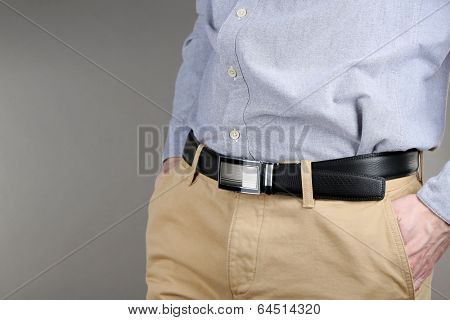 Man in trousers and shirt on grey background