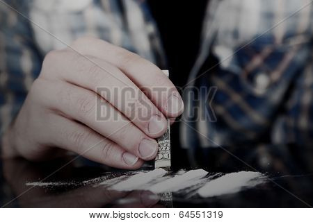 Drug abuse concept - man snorting cocaine