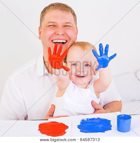 young father and his daughter playing with fingerpaints at home