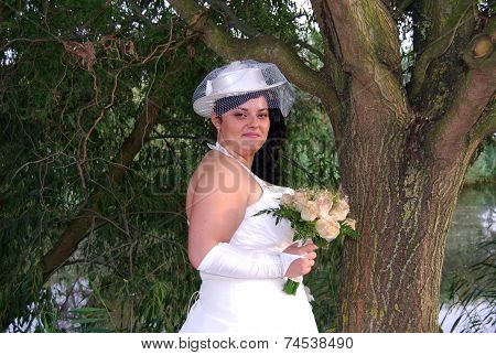 Young brunette overweight bride posing for the camera outdoors