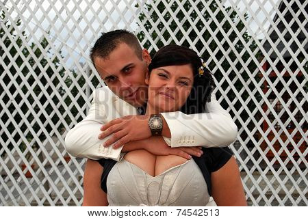 Young bride and groom couple posing outside